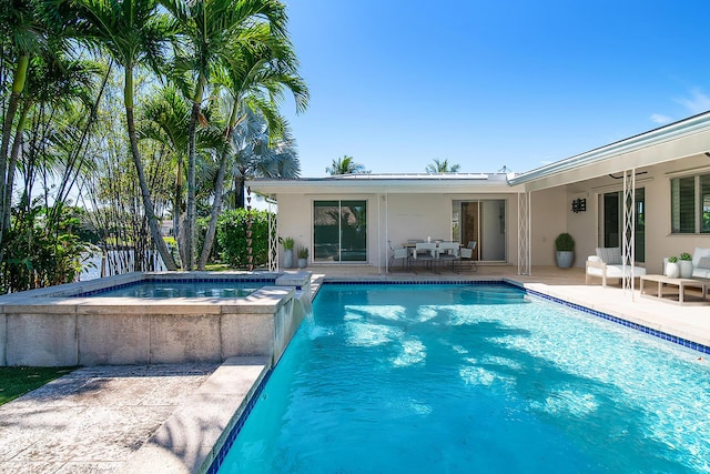 view of swimming pool featuring outdoor dining space, a patio area, and a pool with connected hot tub