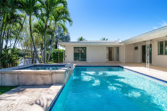 outdoor pool featuring an in ground hot tub and a patio area