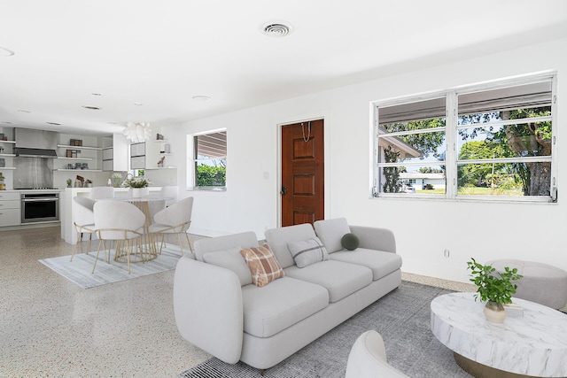 living room featuring visible vents and light speckled floor