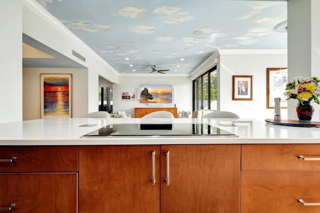 kitchen featuring visible vents, light countertops, crown molding, black electric cooktop, and open floor plan