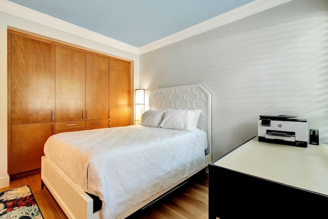 bedroom featuring wood finished floors and ornamental molding