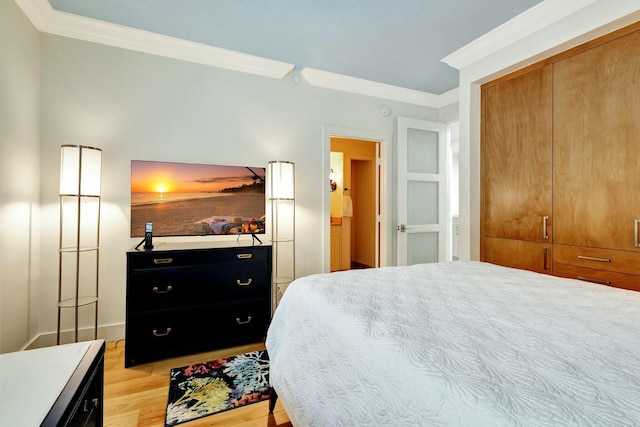 bedroom with light wood finished floors, a closet, and ornamental molding