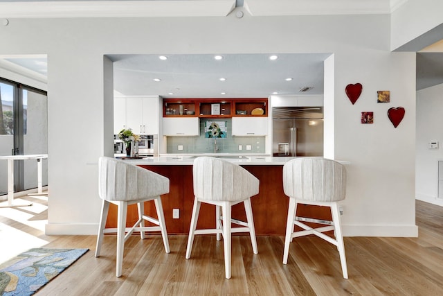 kitchen with backsplash, appliances with stainless steel finishes, light wood-style floors, white cabinets, and open shelves