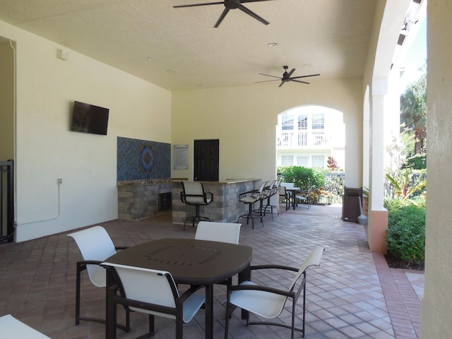 view of patio featuring outdoor dry bar, outdoor dining space, and a ceiling fan