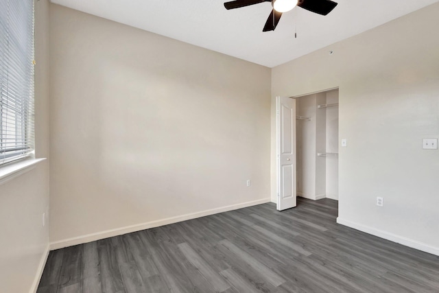 unfurnished bedroom with dark wood-type flooring, baseboards, a closet, and ceiling fan