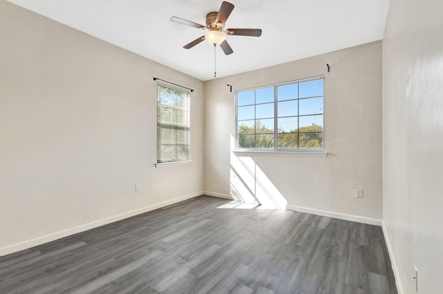 empty room featuring ceiling fan, baseboards, and dark wood-style floors