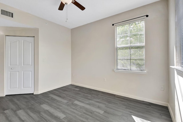 spare room with visible vents, baseboards, a ceiling fan, and wood finished floors