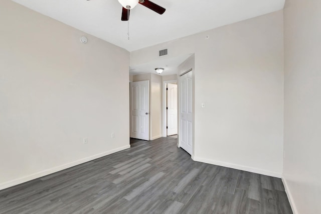 empty room featuring visible vents, baseboards, wood finished floors, and a ceiling fan