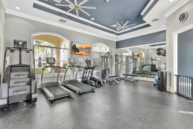 workout area with visible vents, a raised ceiling, a ceiling fan, and ornamental molding