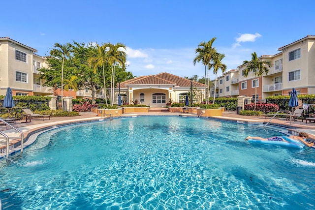 community pool featuring a patio and fence