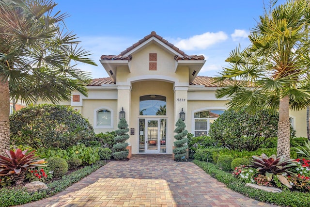 exterior space featuring french doors, stucco siding, and a tile roof