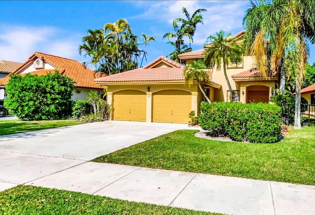 mediterranean / spanish-style home featuring stucco siding, driveway, a front yard, an attached garage, and a tiled roof