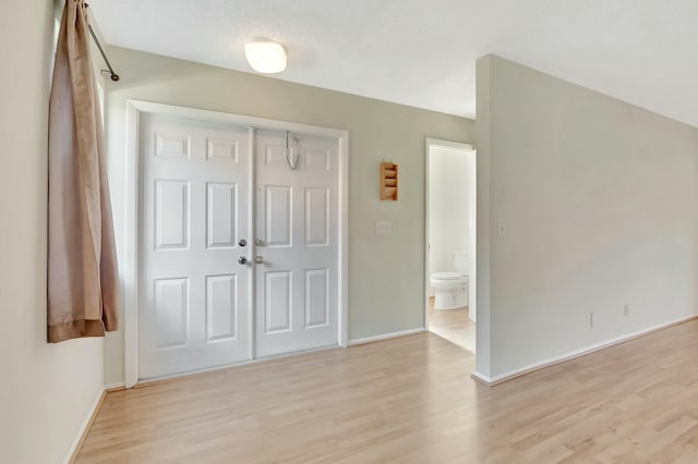 entrance foyer featuring light wood-type flooring and baseboards