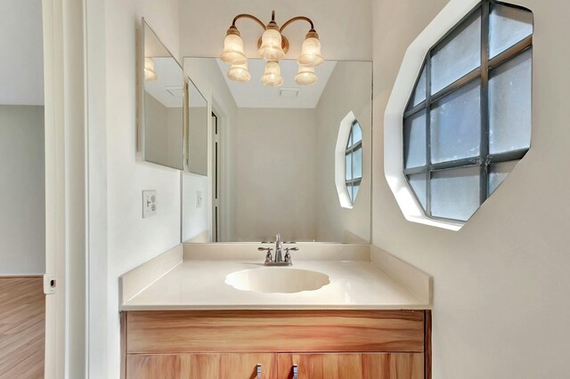 bathroom featuring a notable chandelier and vanity