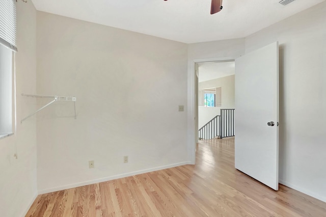 empty room featuring visible vents, light wood-style flooring, baseboards, and a ceiling fan
