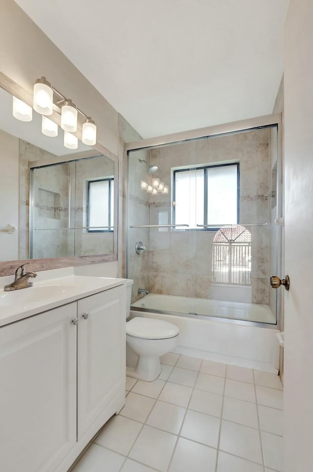 bathroom featuring toilet, plenty of natural light, tile patterned flooring, and enclosed tub / shower combo