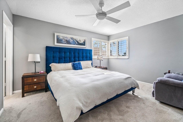 bedroom featuring a textured ceiling, baseboards, ceiling fan, and carpet floors