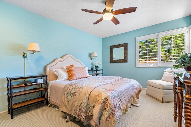 carpeted bedroom with a ceiling fan, baseboards, and a textured ceiling