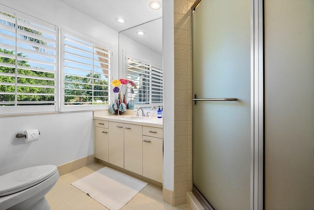 bathroom featuring tile patterned floors, toilet, a stall shower, baseboards, and vanity