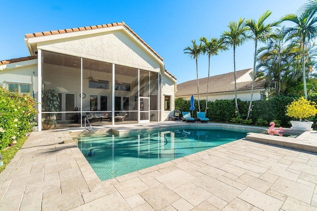 outdoor pool featuring a ceiling fan, a patio area, and a sunroom