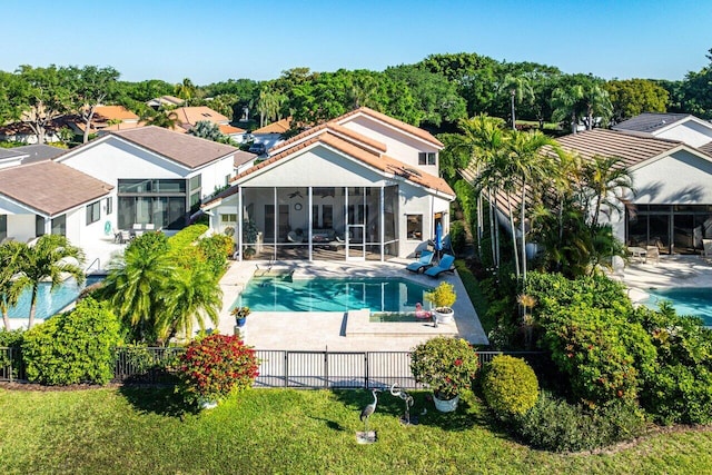 rear view of house with a ceiling fan, a patio area, a fenced backyard, and a sunroom