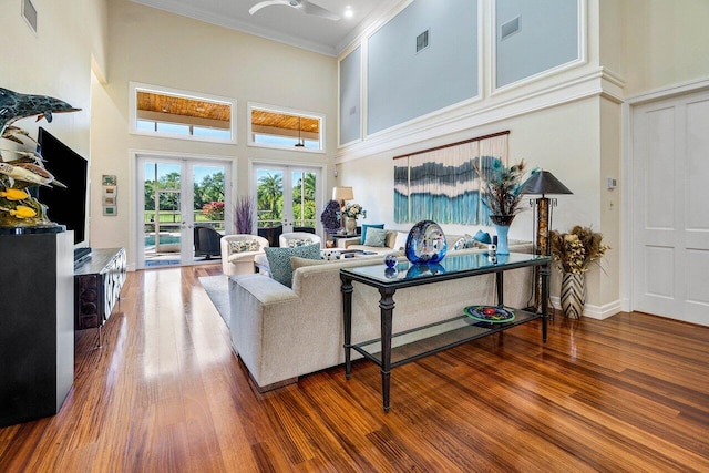 living area with visible vents, wood finished floors, and crown molding