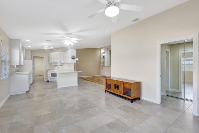 kitchen featuring visible vents, white cabinetry, white appliances, light countertops, and baseboards