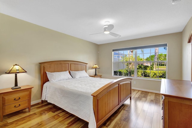 bedroom with baseboards, light wood-style floors, and ceiling fan