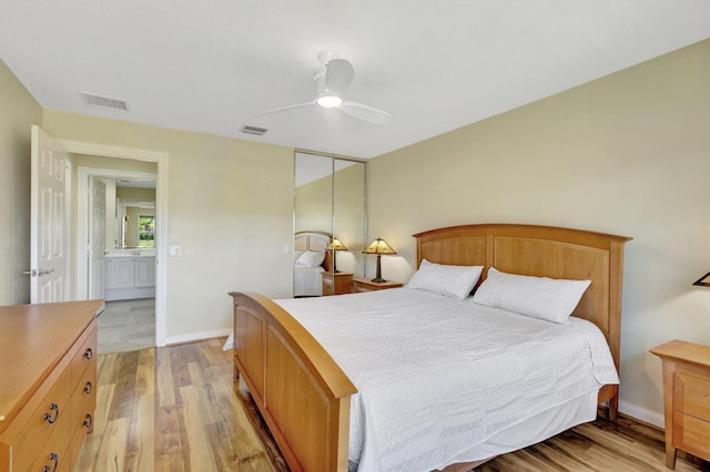 bedroom featuring a ceiling fan, visible vents, and light wood finished floors