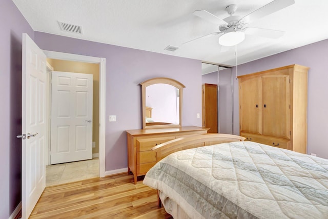 bedroom with a ceiling fan, baseboards, visible vents, and light wood-type flooring