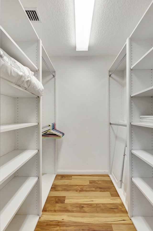 spacious closet with visible vents and light wood-style flooring