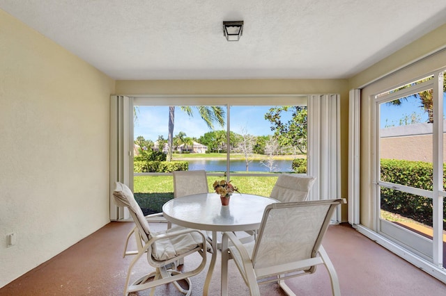 sunroom / solarium with a water view and a healthy amount of sunlight