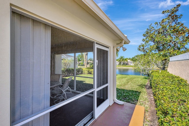 view of patio featuring a sunroom and a water view