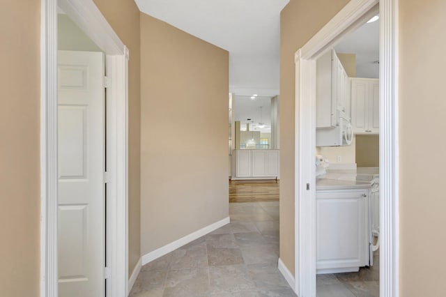 hall with baseboards and washer / clothes dryer