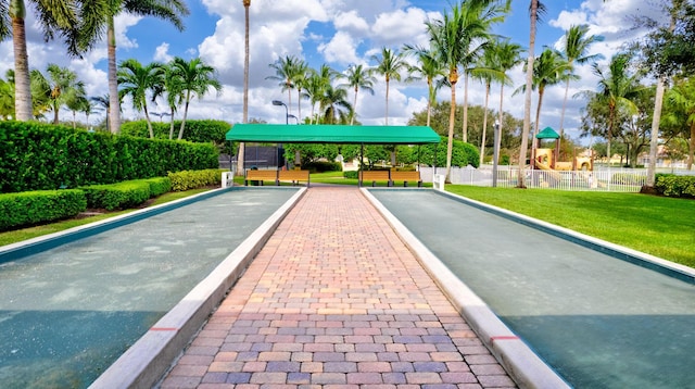 view of home's community featuring a yard, playground community, and fence