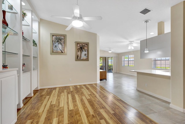 interior space featuring light wood-style flooring, baseboards, and visible vents