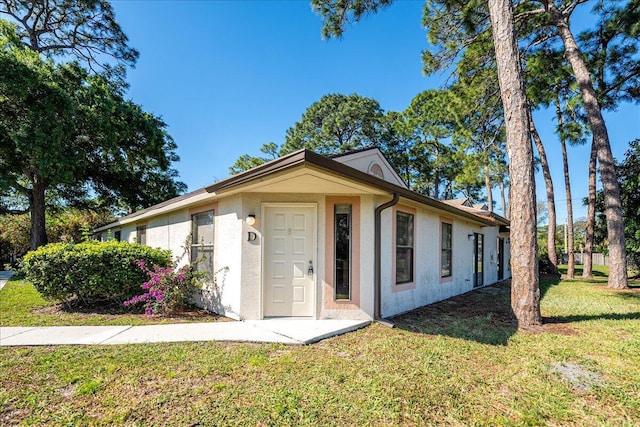 ranch-style home with stucco siding and a front yard