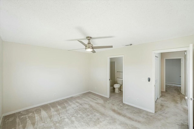 unfurnished bedroom with baseboards, visible vents, ensuite bath, a textured ceiling, and light colored carpet