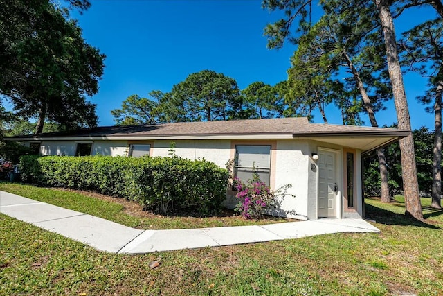 view of side of property with stucco siding and a yard