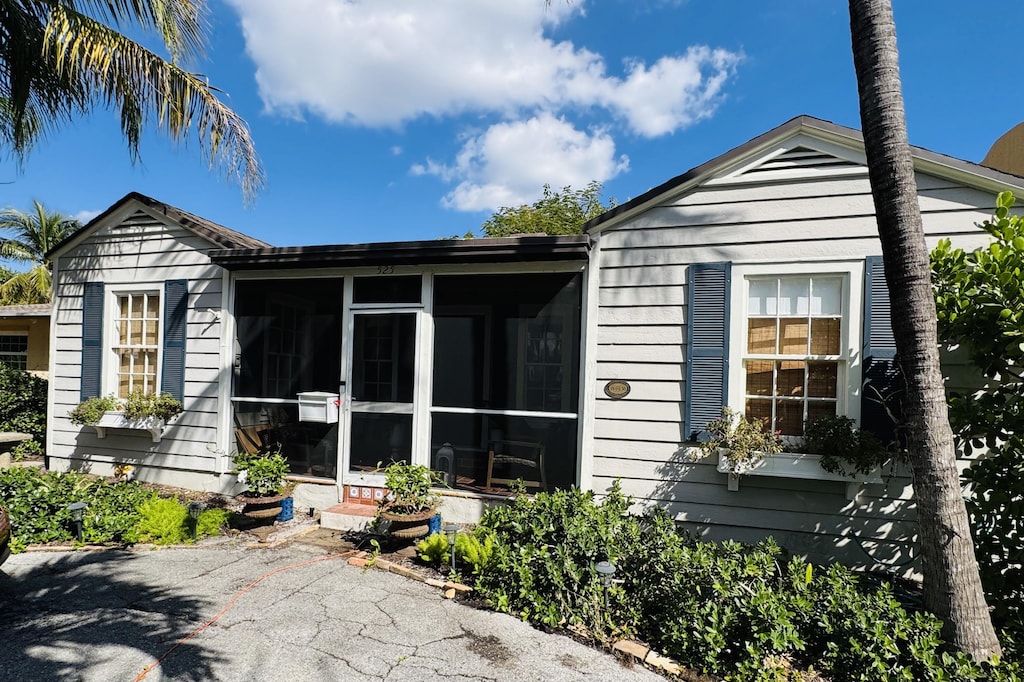 rear view of house featuring a sunroom