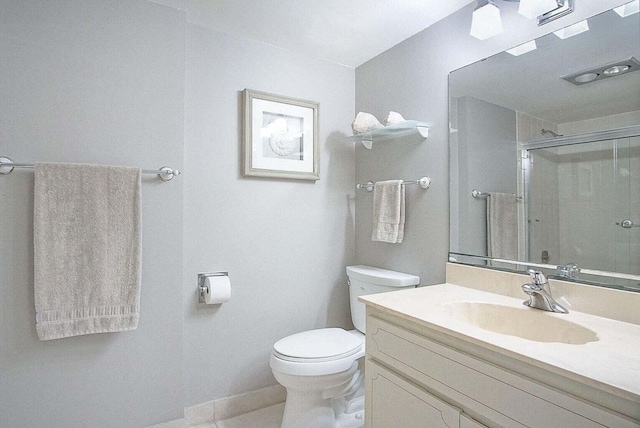 full bathroom featuring vanity, a shower stall, toilet, and baseboards