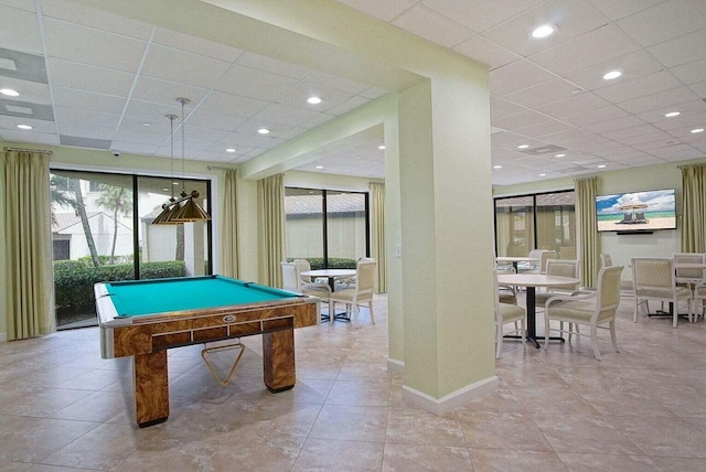 recreation room with a drop ceiling, plenty of natural light, and baseboards