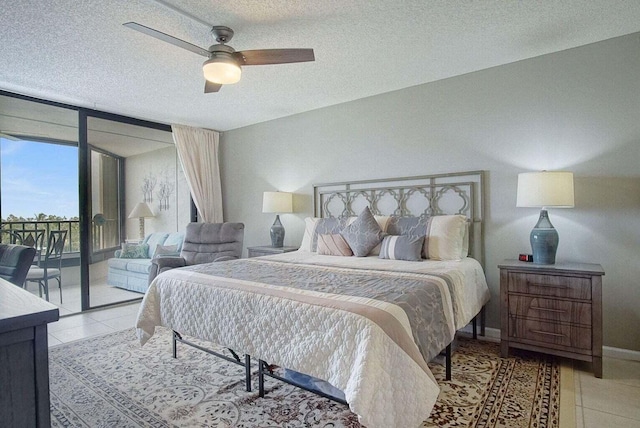 bedroom with light tile patterned floors, baseboards, access to exterior, floor to ceiling windows, and a textured ceiling