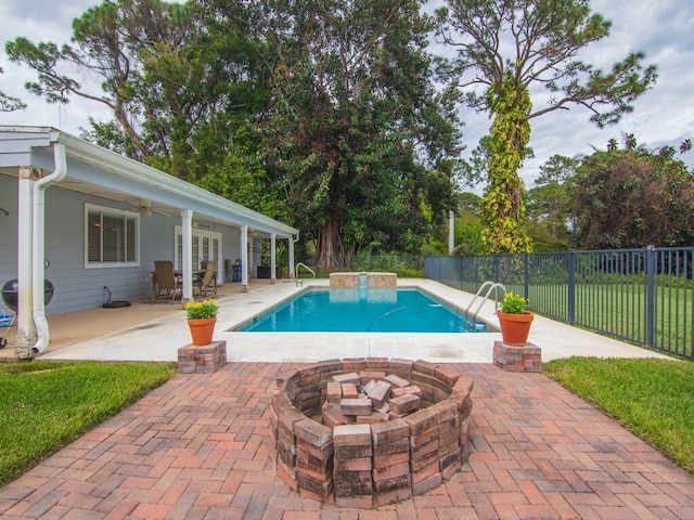 view of swimming pool with a fenced in pool, a fire pit, fence, a patio, and a ceiling fan