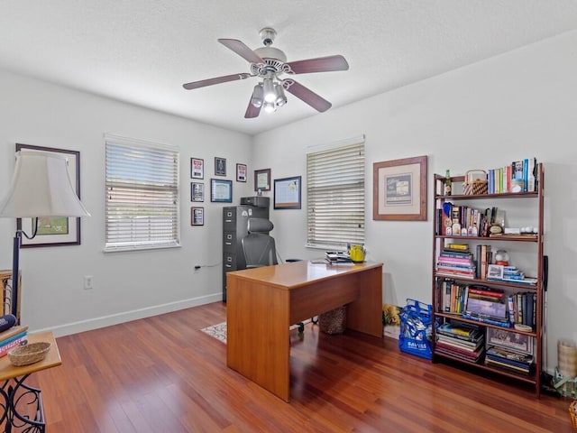 office area featuring ceiling fan, a textured ceiling, baseboards, and wood finished floors