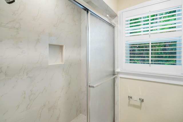 bathroom featuring a marble finish shower