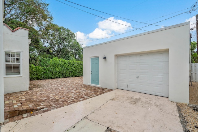 garage featuring fence and driveway