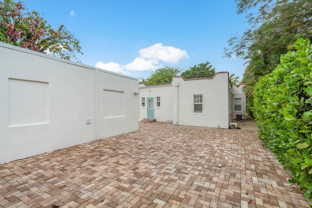 back of property featuring a patio area, central AC unit, and stucco siding