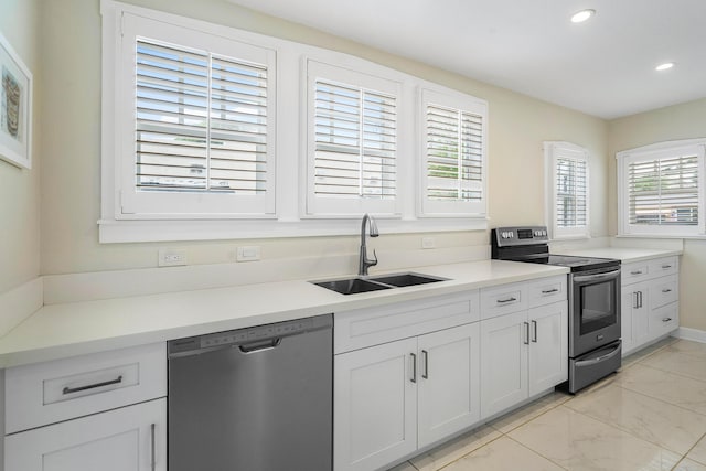 kitchen featuring light countertops, recessed lighting, marble finish floor, stainless steel appliances, and a sink