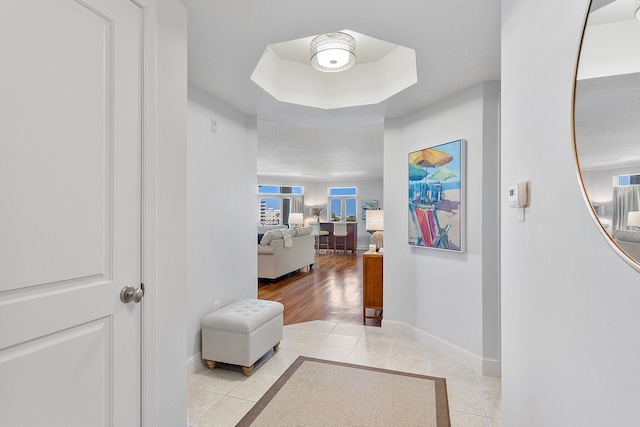 corridor with light tile patterned floors and baseboards